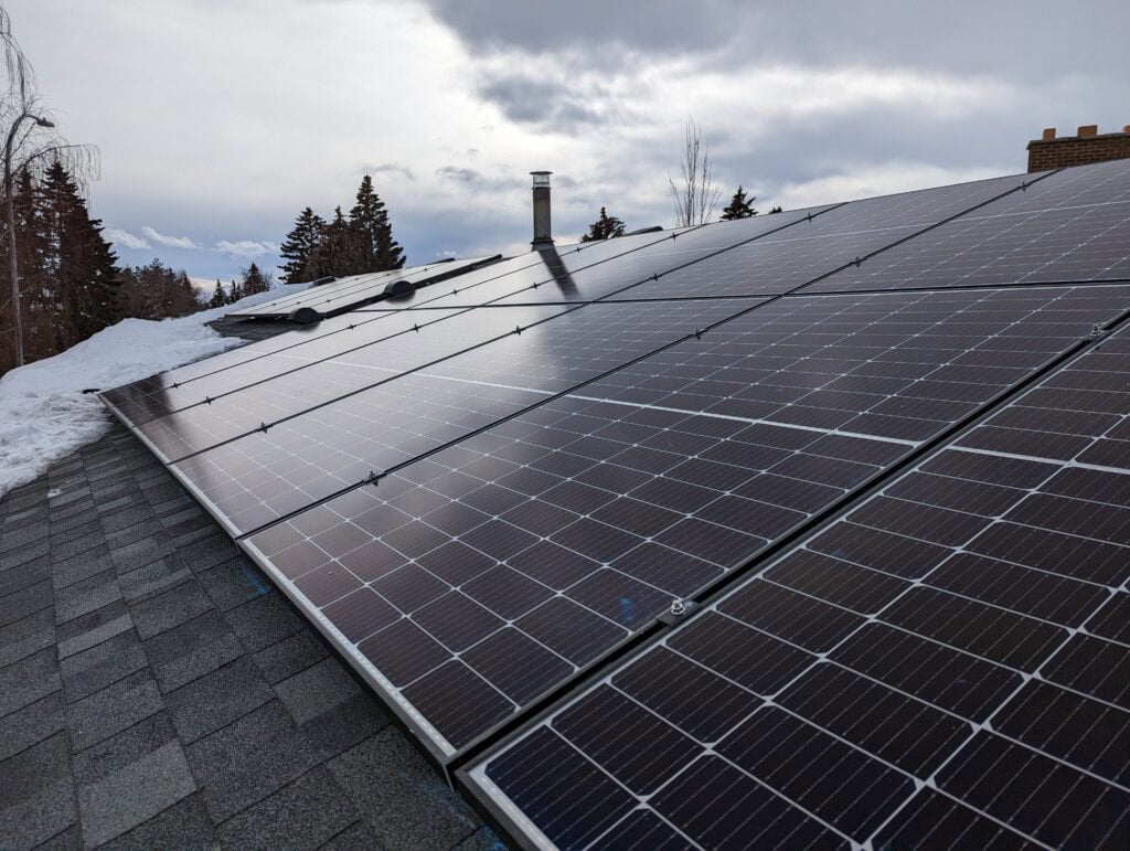 Solar panels working in Calgary winter with snow partially covering the array